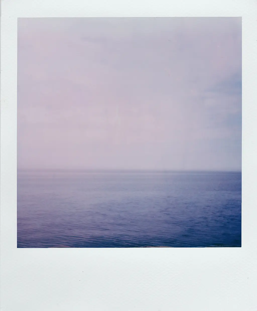 Polaroid avec une mer calme et un ciel sns nuages pour la FAQ informatique
